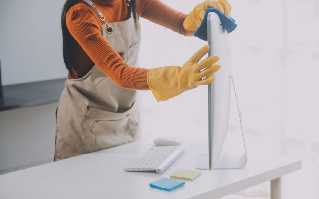 A woman cleans an office monitor