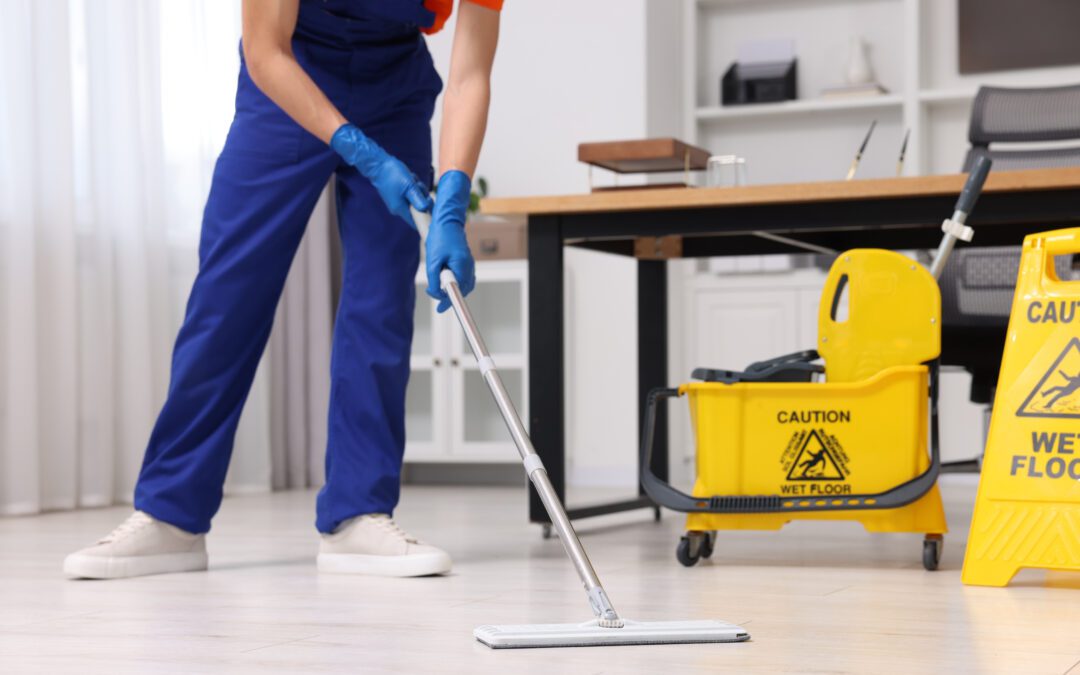 Closeup of a local cleaning service worker washing a commercial floor with a mop.