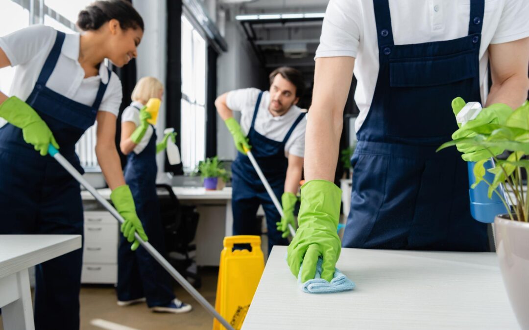 Janitorial team cleaning an office space, wearing gloves for hygiene and safety